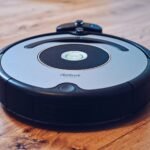 Close-up of a robotic vacuum cleaner operating on a hardwood floor, showcasing modern cleaning technology.
