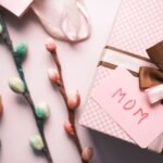 Elegant pink gift box with flowers and a 'Mom' card, perfect for Mother's Day celebrations.