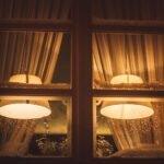 A cozy view with warm light through a window during a snowy winter night.
