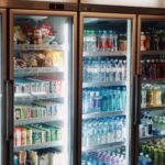 Refrigerator display with various beverages and snacks in a store environment.