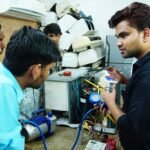 Participants learn AC repair during a hands-on session in Delhi, India.