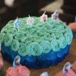 A Frozen-themed birthday cake with blue frosting and matching cupcakes. Perfect for a child's celebration.