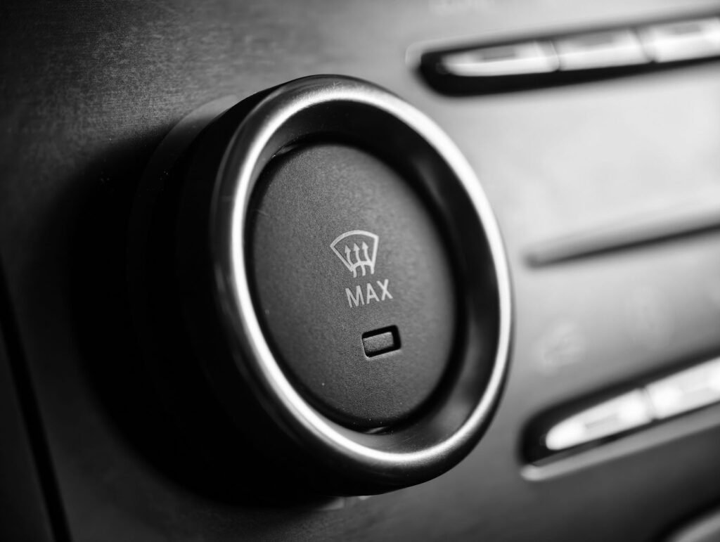 Black and white close-up of a car defroster control dial with max setting.