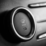 Black and white close-up of a car defroster control dial with max setting.