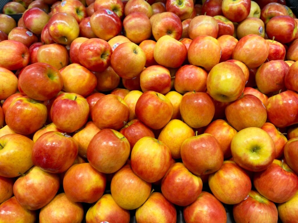 Pile of fresh red and yellow apples at a grocery store, perfect for healthy eating and autumn themes.