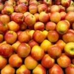 Pile of fresh red and yellow apples at a grocery store, perfect for healthy eating and autumn themes.