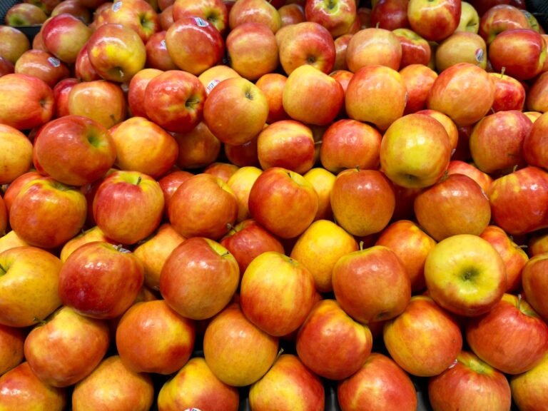Pile of fresh red and yellow apples at a grocery store, perfect for healthy eating and autumn themes.