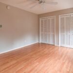 Bright empty room with hardwood floors and closet space, ideal for various design choices.