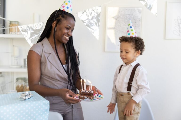 A woman and boy celebrate a birthday with cake and party hats indoors.