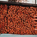 A large stack of chopped firewood stored outdoors, ready for use.