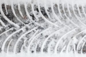 Close-up of a tire track in fresh snow showcasing a unique pattern and texture.