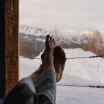 Relaxing view of snowy mountains from a warm cabin in winter.