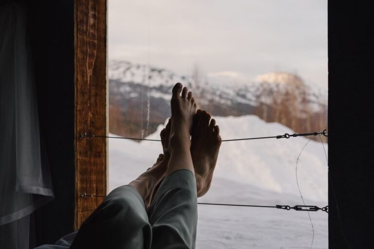 Relaxing view of snowy mountains from a warm cabin in winter.