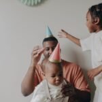 Father with children enjoying a birthday party indoors with decorations.