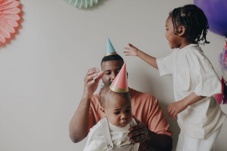 Father with children enjoying a birthday party indoors with decorations.