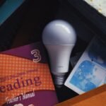From above of light bulb placed among books in pull out drawer in daytime