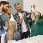 A joyful family birthday celebration with grandparents and children wearing party hats inside a cozy home.