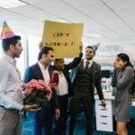 Surprise office birthday celebration with joyful colleagues and festive decorations.