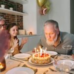 A family birthday celebration featuring a cake with lit candles and joyful togetherness.
