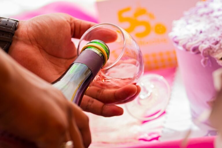Close-up of hands pouring champagne for a festive celebration indoors.