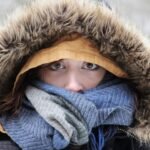 Close-up of a person bundled in winter clothes with a furry hood and scarf.