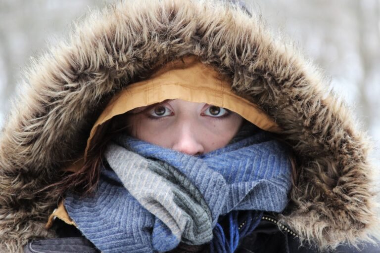 Close-up of a person bundled in winter clothes with a furry hood and scarf.