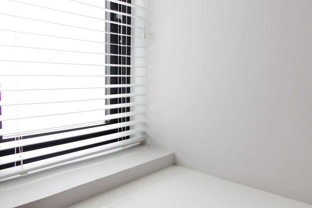 Bright minimalist interior with white window blinds and smooth wall, perfect for modern design.