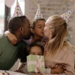A joyful family celebration with parents and children enjoying a birthday party, complete with hugs and gift giving.